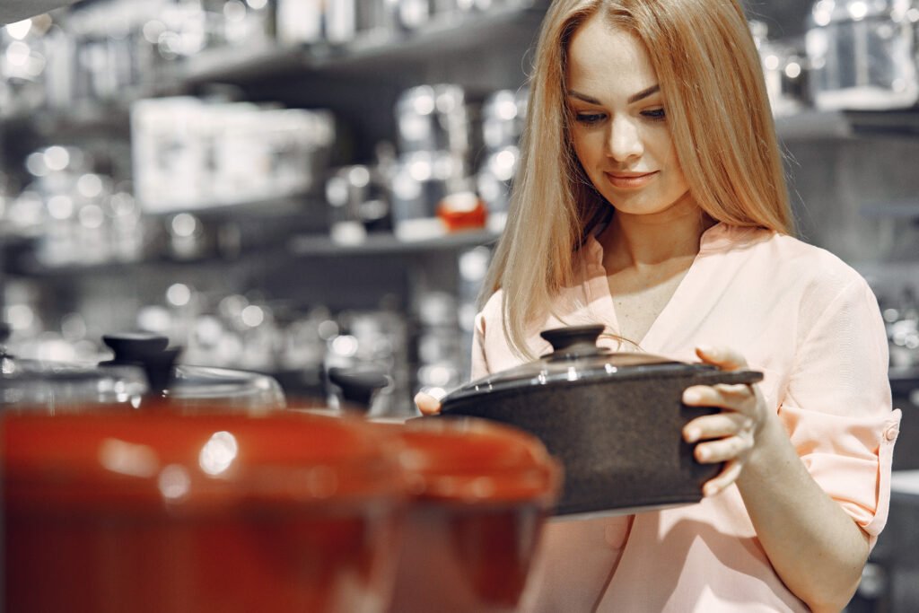 woman-pink-blouse-buys-dishes-store-1-1024x683 Melhor Jogo de Panelas de 2025: Guia Completo